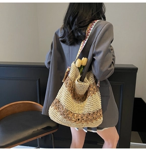 Detail of woven straw tote bag with vibrant geometric patterned shoulder strap