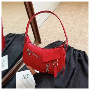 Macro detail of red lychee grain leather handbag with silver metallic zippers and hardware