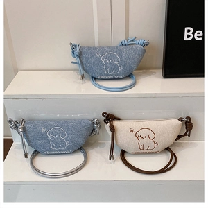 Détail de sacs bandoulière en demi-lune avec broderie de chien et bandoulière nouée