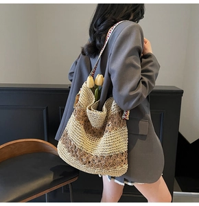 Detail of hollow-out woven tote with ethnic embroidery strap and straw texture
