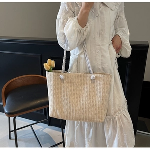 Detailed straw tote bag texture with white cotton rope handles and tulip floral accents