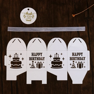 Flat lay of DIY white party favor box template with Happy Birthday cake patterns and ribbon