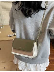 Vintage tricolor crossbody bag in green and cream worn by model in a warm interior