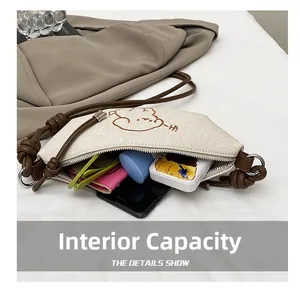 Détails de l'intérieur d'un sac en toile crème avec motif ours et bandoulière en corde