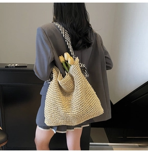 Detailed side view of woven tote bag with ribbon straps and floral decorative accents