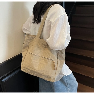 Detailed back view of a khaki large-capacity tote bag worn on shoulder by a model