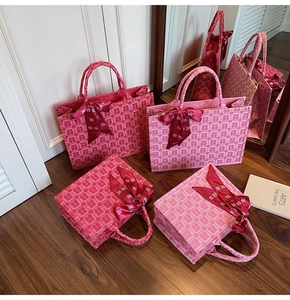 Close-up of red Chinese wedding tote bags with Xi character jacquard and silk bow detail