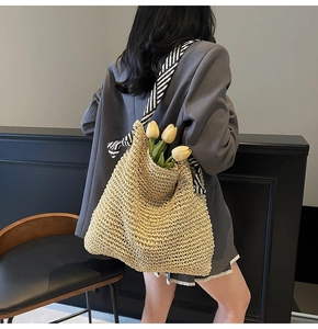Detailed shot of beige mesh woven tote bag with a striped silk scarf handle accent