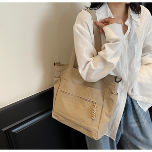 Detailed view of khaki nylon tote bag with front zipper pocket and side pocket for daily use