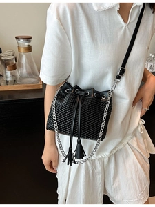 Modern black woven bucket bag with tassel drawstring and silver chain strap for women