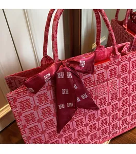 Detailed texture of red bridal tote bag with Xi character pattern and silk bow ornament