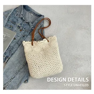 Close-up of cream woven tote bag with brown leather handles and metal rivet details