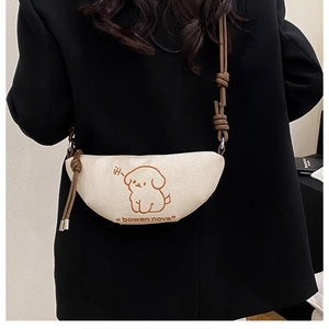 Détail du sac demi-lune beige avec illustration de chien et bandoulière marron