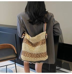 Detailed shot of the woven straw shoulder bag with star cutouts and colorful strap