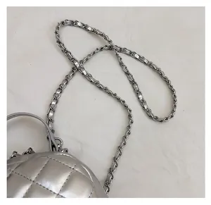 Detail of silver quilted leather backpack with woven chain strap and metallic finish
