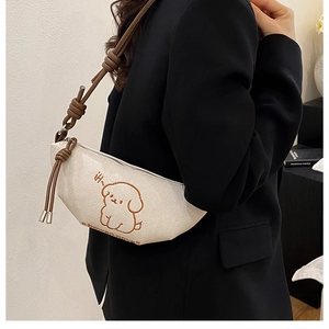 Détail de la broderie chien et des nœuds sur le sac bandoulière en toile crème