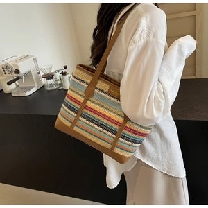 Detail of colorful woven tote bag with brown leather handles in a cozy cafe setting