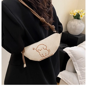 Détail de la broderie chiot sur sac bandoulière crème avec sangle en cuir marron nouée