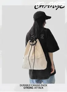 Außenaufnahme eines beigen Nylon-Rucksacks mit Kordelzug und schwarzen Riemen