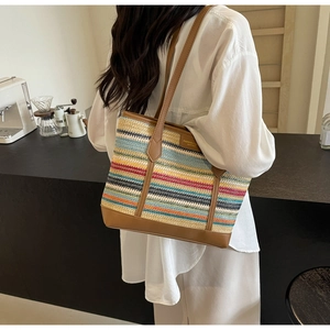 Detail of colorful striped woven tote bag with brown leather handles and side fashion tag