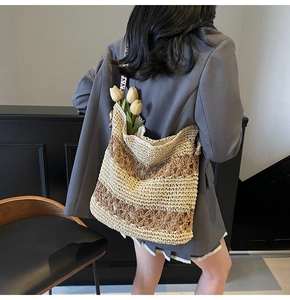 Detail of hollow woven straw tote bag with colorful bohemian ribbon strap and floral pattern