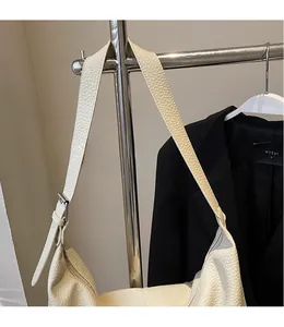 Detail of adjustable long shoulder strap on cream lychee pattern hobo tote bag