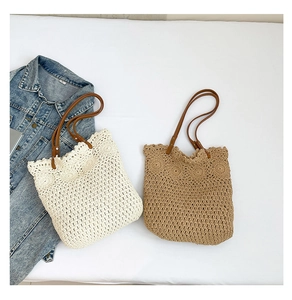 Detail of woven knit tote bag with sun flower patterns and brown faux leather handles
