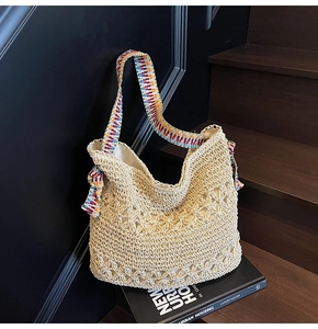 Detail of hand-woven straw tote with colorful geometric patterned jacquard shoulder strap