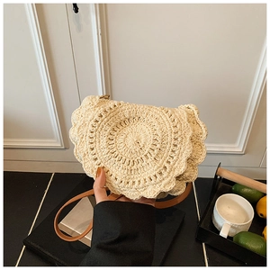 Detail of hand-woven saddle bag featuring intricate wavy hollow crochet trim and leather strap