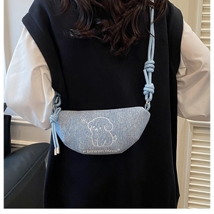 Détail du sac bandoulière en denim bleu clair avec imprimé chien et bandoulière nouée