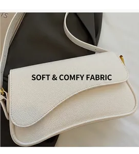 Detail view of the asymmetric wave flap and lychee textured leather on white shoulder bag