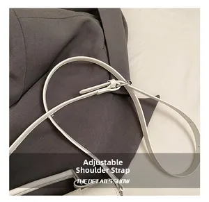 Detail of white adjustable synthetic leather shoulder strap with silver buckle and stitching