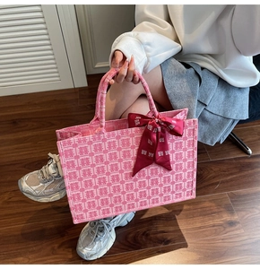 Detailed texture of pink woven tote bag with Double Happiness symbols and red silk bow
