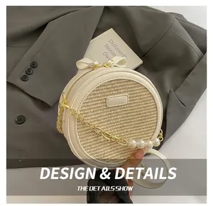 Detail view of woven round bag featuring pearl-embellished gold chain and bow handle