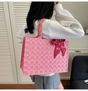 Detail of pink Chinese wedding tote bag with double happiness jacquard and silk ribbon decoration
