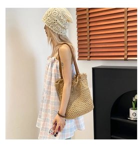 Close-up of woven shoulder bag with floral crochet details and brown leather straps