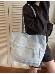 Large light blue crinkled nylon tote bag with side pockets for daily commute