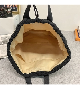 Innenansicht der schwarzen Nylon-Kordelzug-Tragetasche mit beigem Futter und Innentasche