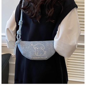 Détail du sac bandoulière en denim bleu clair avec motif chien et sangle nouée