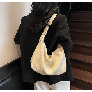 Close-up of cream pebble grain leather hobo bag with adjustable wide shoulder strap
