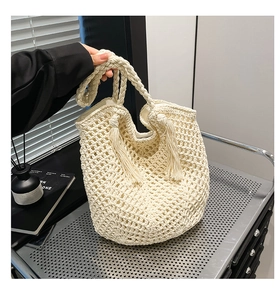 Detailed view of woven tote bag with hollow grid pattern and elegant fringe tassel decor
