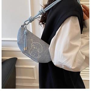 Vue détaillée du sac demi-lune en denim bleu clair avec broderie chiot et noeud