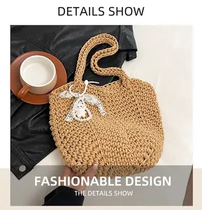 Detail shot of khaki woven bag texture with white lace bow and pearl chain pendant