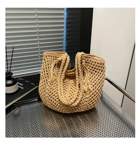Detailed close-up of a hollow crochet woven beach tote bag with stylish tassel decoration