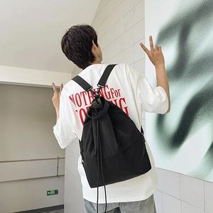 Rückansicht eines schwarzen Nylon-Kordelzug-Rucksacks mit breiten Trägern am Model