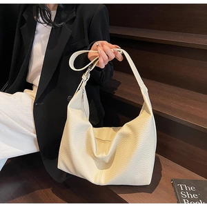 Detail of off-white lychee grain leather hobo bag with soft texture and shoulder strap