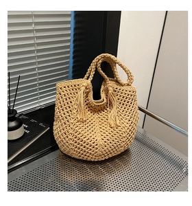 Close-up of oatmeal woven hollow tote bag featuring mesh texture and tassel detail