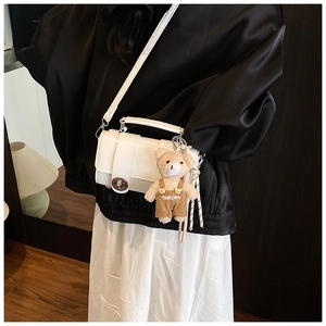 Elegant white glossy mini handbag with silver hardware and a cute teddy bear charm