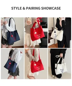 Détail des sacs fourre-tout en toile bleu marine, rouge et beige avec broderie