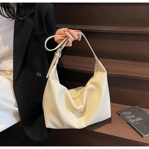 Detail of cream white lychee pattern leather on a large minimalist hobo shoulder bag